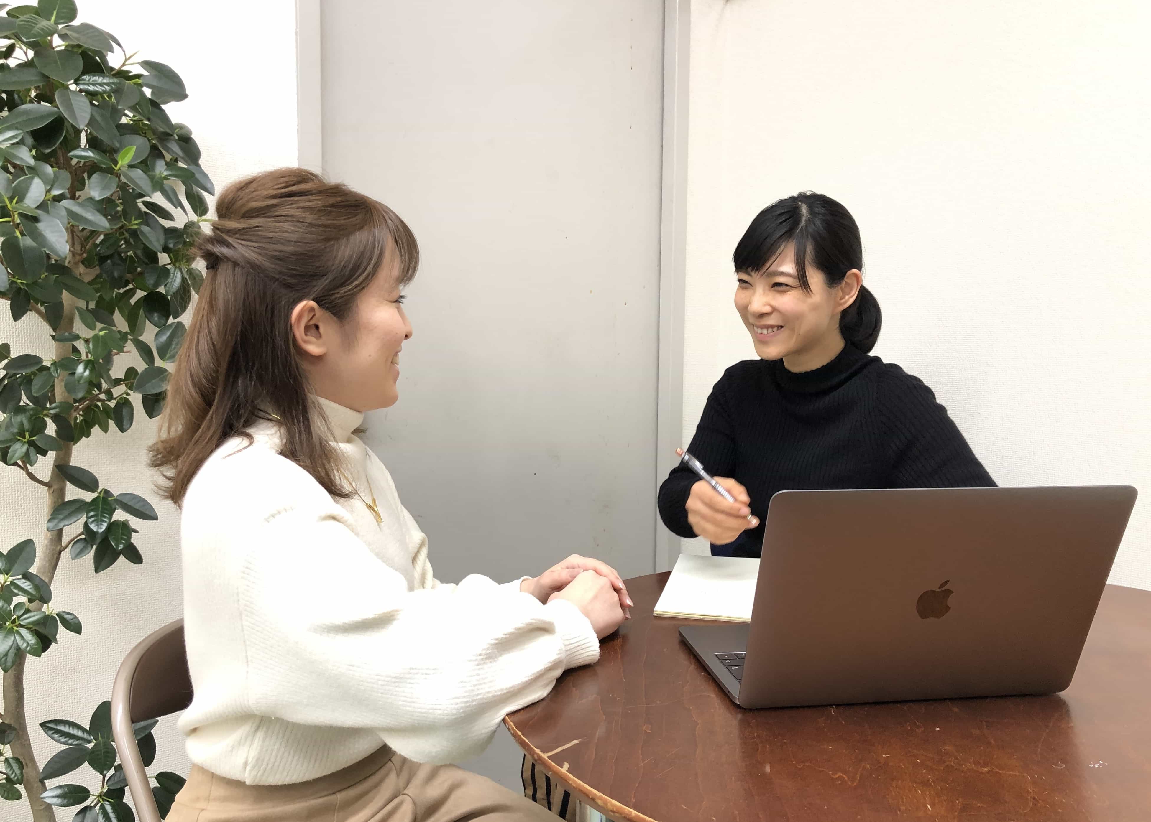 教室のテーブルでスタッフに相談する来校者