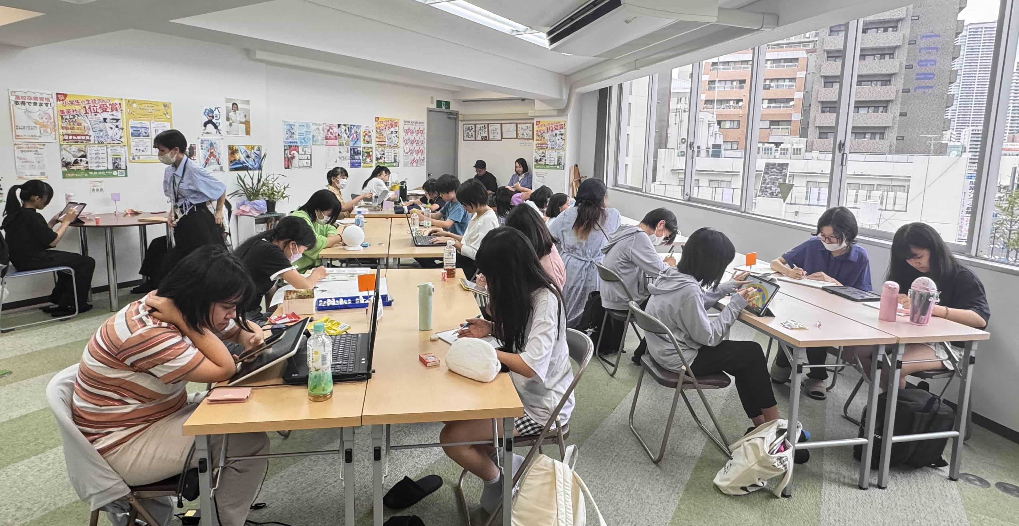 窓際まで席が並ぶ教室で、思い思いに制作する受講生