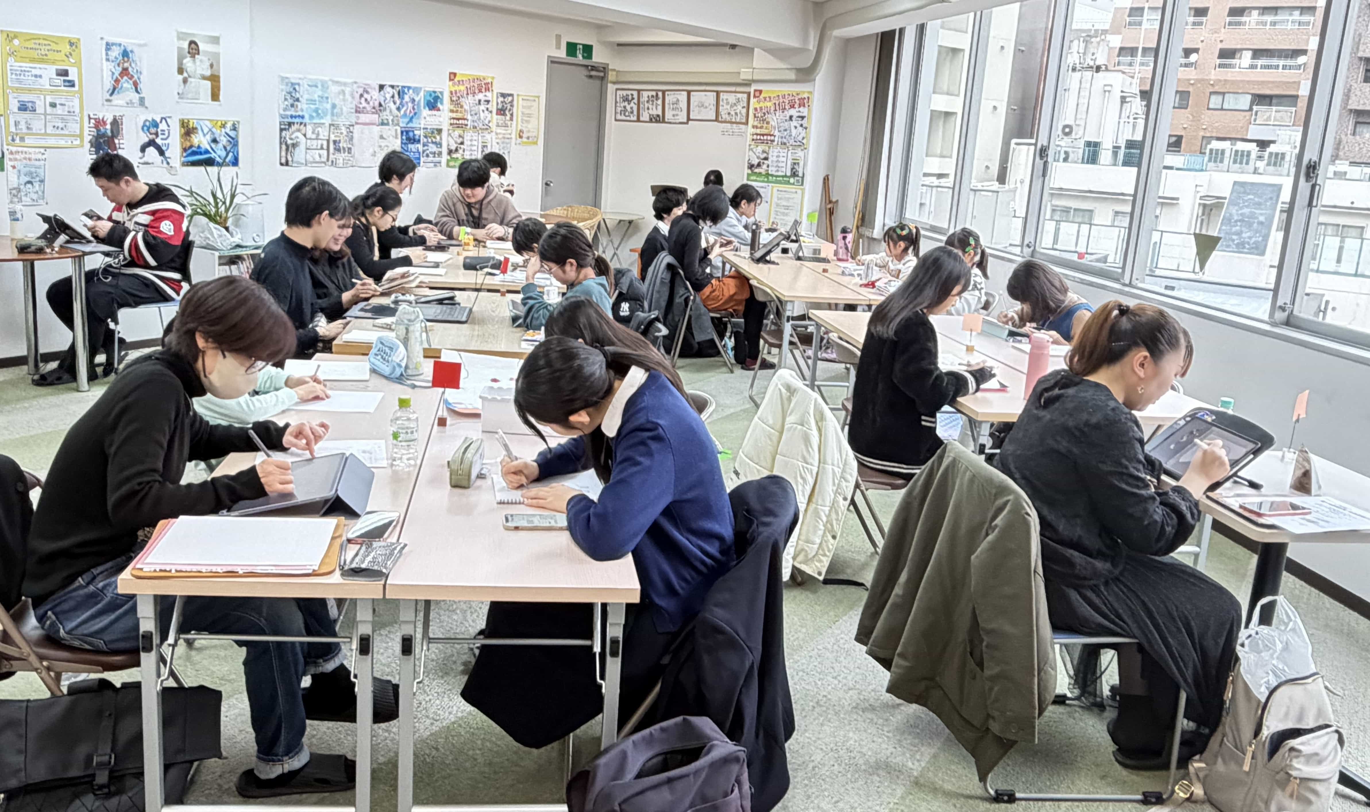 明るい教室でそれぞれの作品に集中する生徒たち